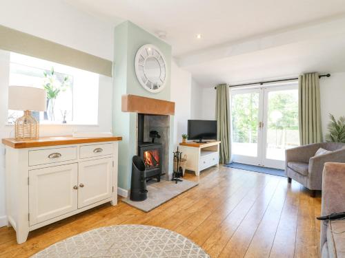 a living room with a fireplace and a tv at The Old Parlour in Alton