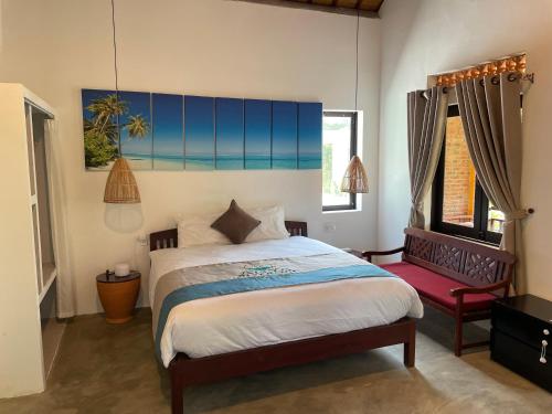 Un dormitorio con una cama grande y una silla roja. en Hoi An Villa near An Bang Beach, en An Bàn (2)