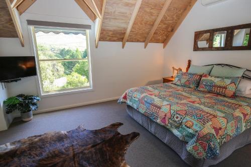 a bedroom with a bed and a large window at Bonnie's Cottage - Peaceful retreat in Wandiligong