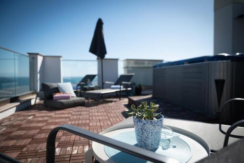 a patio with a table and chairs on a balcony at Queen's Penthouse Balchik apartment in Balchik