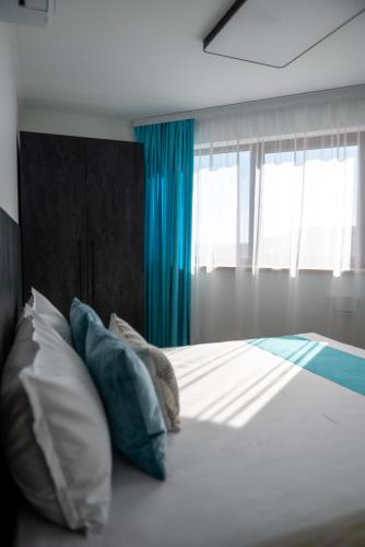 a bedroom with a bed with pillows and a window at Queen's Penthouse Balchik apartment in Balchik
