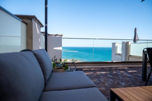 a couch on a balcony with a view of the ocean at Queen's Penthouse Balchik apartment in Balchik
