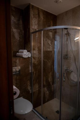 a bathroom with a shower with a toilet and a sink at Queen's Penthouse Balchik apartment in Balchik