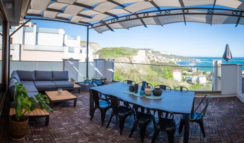 a patio with a blue table and chairs and a couch at Queen's Penthouse Balchik apartment in Balchik