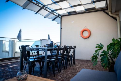 a table and chairs on a balcony with a clock at Queen's Penthouse Balchik apartment in Balchik