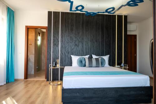 a bedroom with a large bed with a black headboard at Queen's Penthouse Balchik apartment in Balchik