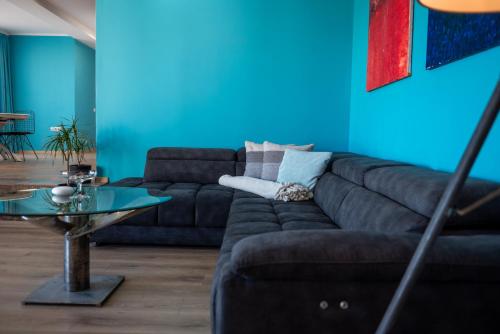 a living room with a couch and a blue wall at Queen's Penthouse Balchik apartment in Balchik