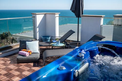 a plunge pool with chairs and an umbrella at Queen's Penthouse Balchik apartment in Balchik