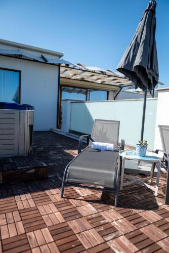 a patio with a chair and an umbrella and a table at Queen's Penthouse Balchik apartment in Balchik