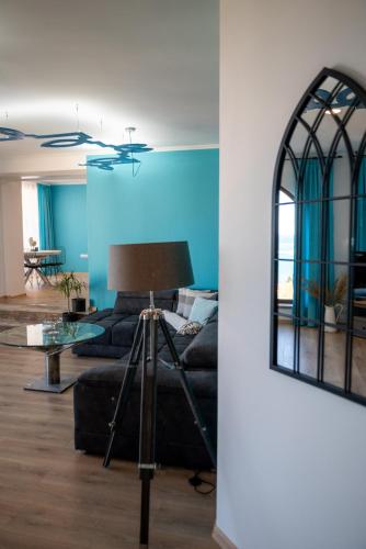 a living room with a black couch and a mirror at Queen's Penthouse Balchik apartment in Balchik