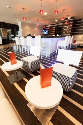 a restaurant with white tables and white chairs at Novotel Tunis in Tunis