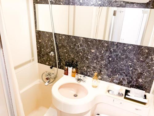 a bathroom with a toilet and a sink at HOTEL LiVEMAX Toyooka in Toyooka