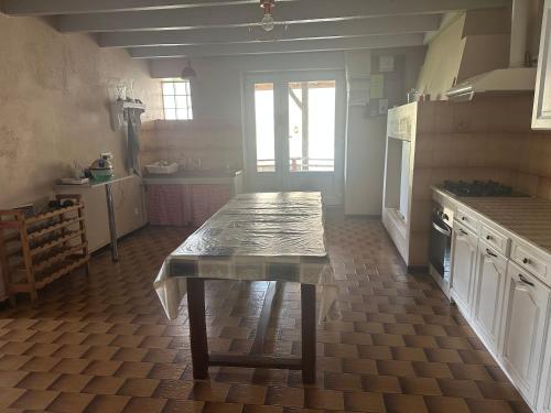 une cuisine avec une table au milieu dans l'établissement Maison de campagne repos paisible chevaux, à Marcenas