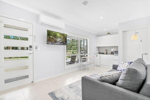 a living room with a couch and a kitchen at Mala Retreat Sleeps 7, Two Bedrooms & Ensuites in East Maitland