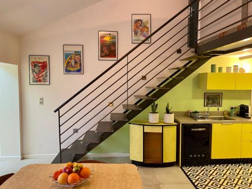 une cuisine avec un escalier avec un bol de fruits sur une table dans l'établissement Atypical 5-person house with patio, downtown, air-conditioning, à Aix-en-Provence