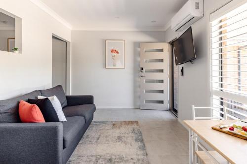 a living room with a couch and a tv at Mala Retreat Sleeps 7, Two Bedrooms & Ensuites in East Maitland