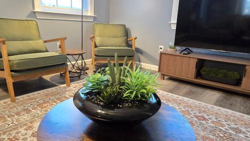 a living room with a tv and a table with plants at Cozy Home Sleeps 6 3 bed 2 bath off I-10 in Mobile