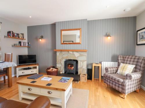 a living room with a couch and a fireplace at Larch in Newtonmore