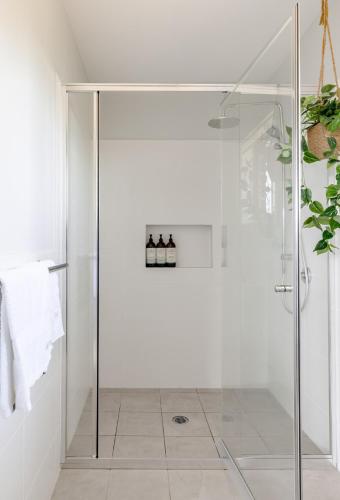 a shower with a glass door in a bathroom at Mala Retreat Sleeps 7, Two Bedrooms & Ensuites in East Maitland