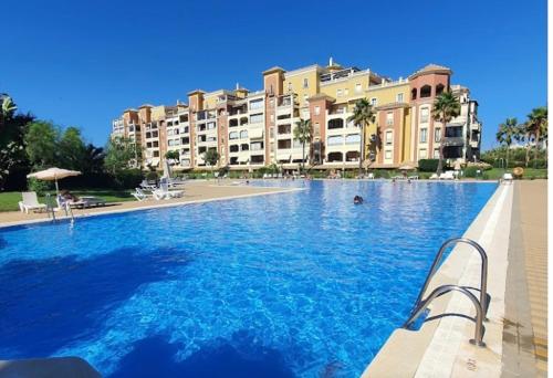 a large swimming pool in front of a large building at Canela Garden in Isla Canela