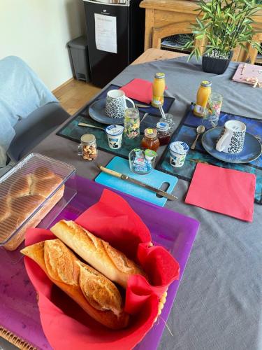 a table with a purple plate with bread on it at La chambre haute, son jardin, et, son SPA in Nîmes