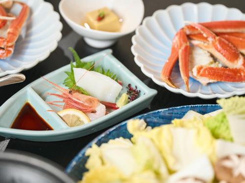 a table topped with plates of food with seafood at Sinonomesou Kinosaki Onsen in Toyooka