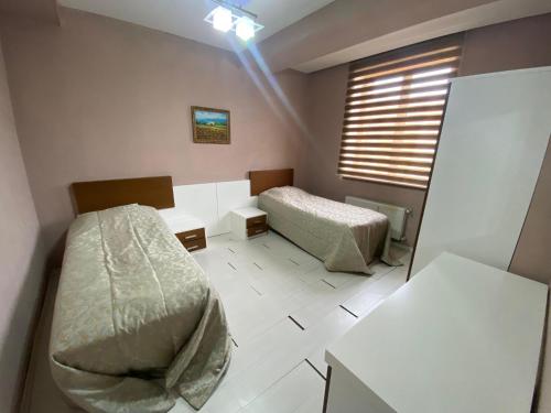 a room with two beds and a window in it at Arena Hotel Dashkasan in Xoşbulaq