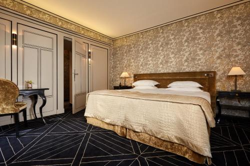 a hotel room with a bed and a desk at Le Pavillon de la Reine & Spa, Place des Vosges in Paris