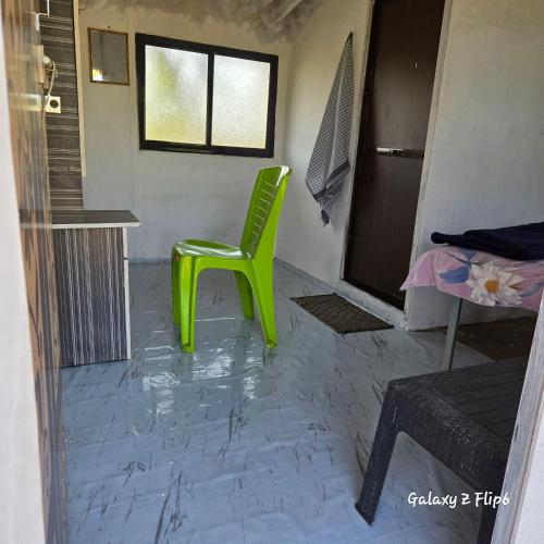 a green chair sitting in the middle of a room at Sea - Touch Beach Resort Harihareshwar in Harihareshwar