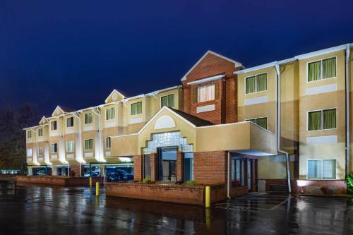 a row of buildings in a parking lot at night at Microtel Inn by Wyndham Lake Norman in Cornelius