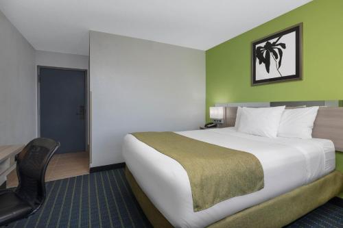 a hotel room with a large bed and a chair at Microtel Inn by Wyndham Lake Norman in Cornelius