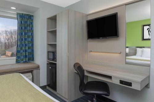 a hotel room with a chair and a television at Microtel Inn by Wyndham Lake Norman in Cornelius