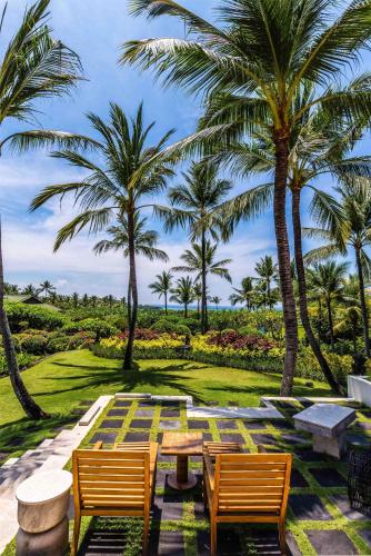 a patio with palm trees and a table and chairs at Grand Hyatt Bali in Nusa Dua