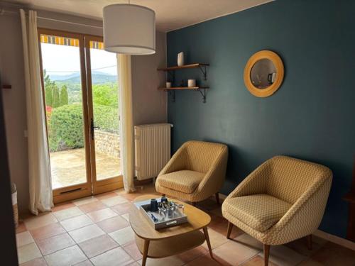 a living room with two chairs and a table at LE LIT QUI DANSE in Mollans-sur-Ouvèze