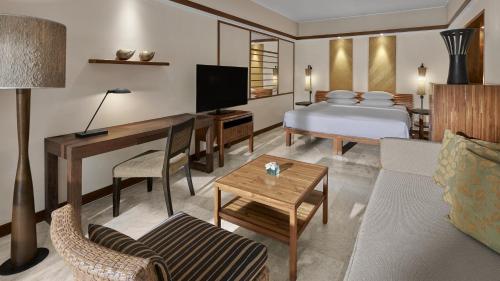 a hotel room with a bed and a living room at Grand Hyatt Bali in Nusa Dua