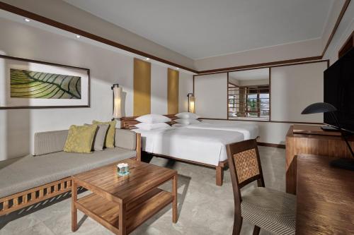 a hotel room with a bed and a couch at Grand Hyatt Bali in Nusa Dua