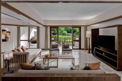 a living room with a couch and a tv at Grand Hyatt Bali in Nusa Dua