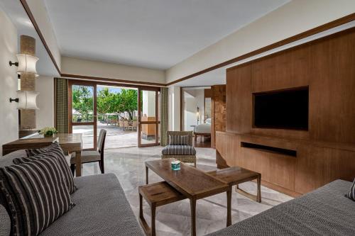 a living room with a couch and a tv at Grand Hyatt Bali in Nusa Dua