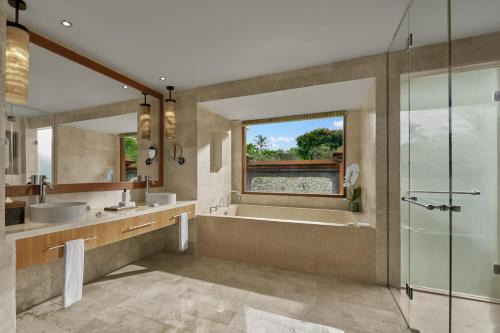 a bathroom with a tub and a sink and a shower at Grand Hyatt Bali in Nusa Dua