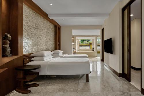 a group of four beds in a room at Grand Hyatt Bali in Nusa Dua