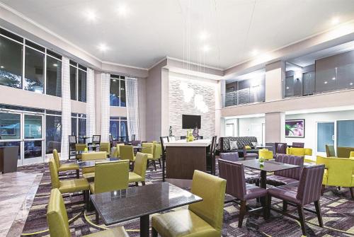 a restaurant with tables and yellow chairs at La Quinta by Wyndham Austin Airport in Austin