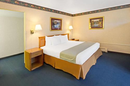 a bedroom with a large bed in a hotel room at Travelodge by Wyndham Rapid City in Rapid City