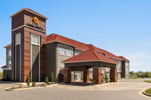 a hotel building with a sign on top of it at La Quinta by Wyndham Shawnee in Shawnee