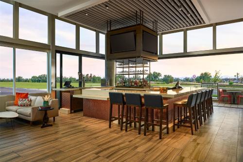 an open kitchen with a bar with chairs and a couch at Hyatt Place Pena Station/Denver Airport in Denver