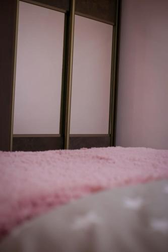 a room with three windows and a bed with pink sheets at MARY in Stepʼanavan