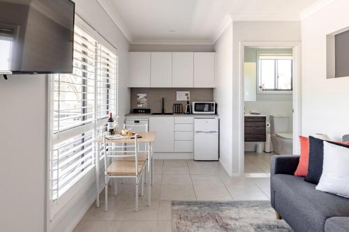 a kitchen and living room with a couch and a table at Mala Retreat, Shiraz Suite 5 Star Immaculate and Comfortable in East Maitland