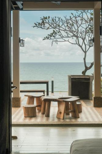 a patio with tables and a view of the ocean at Bonheur at Karambunai in Kota Kinabalu