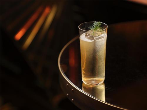 a glass with a plant in it sitting on a table at NoMad London in London