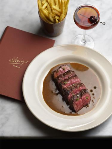 a plate of food with a piece of steak and french fries at NoMad London in London