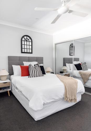 a bedroom with a large white bed and mirrors at Mala Retreat, Shiraz Suite 5 Star Immaculate and Comfortable in East Maitland